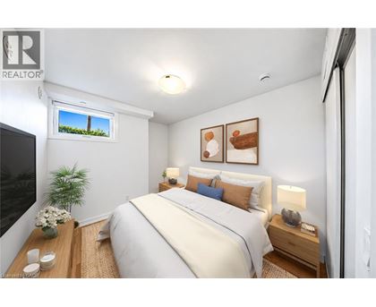 A well-lit bedroom with a large bed and a window showing a view of a green landscape.