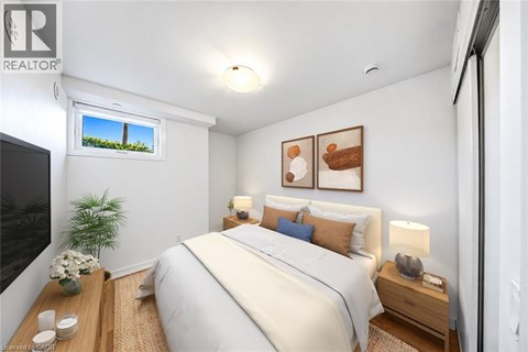 A well-lit bedroom with a large bed and a window showing a view of a green landscape.