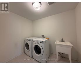 A laundry room with a washer and dryer and a sink.