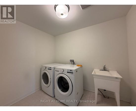 A laundry room with a washer and dryer and a sink.