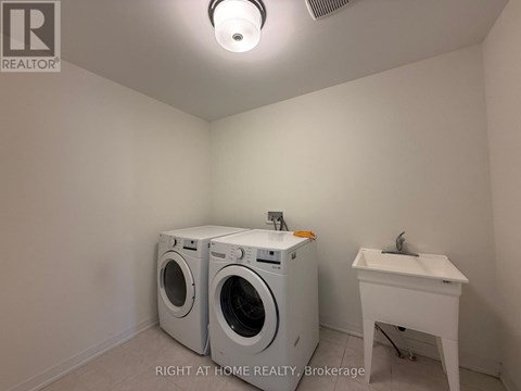 A laundry room with a washer and dryer and a sink.