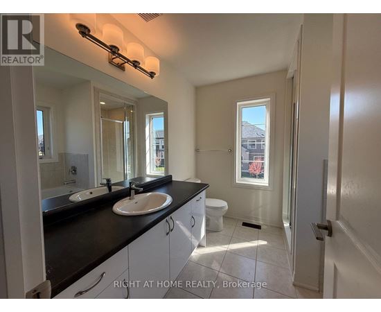 A bathroom with two sinks and a toilet.