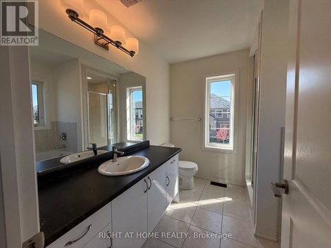 A bathroom with two sinks and a toilet.