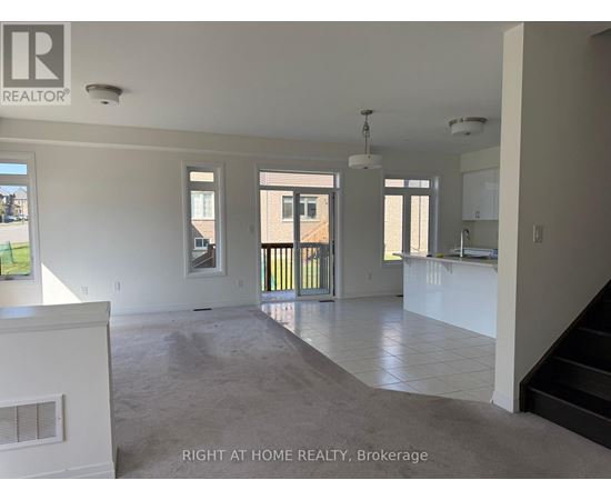 A spacious, empty room with a staircase leading to the upper floor.
