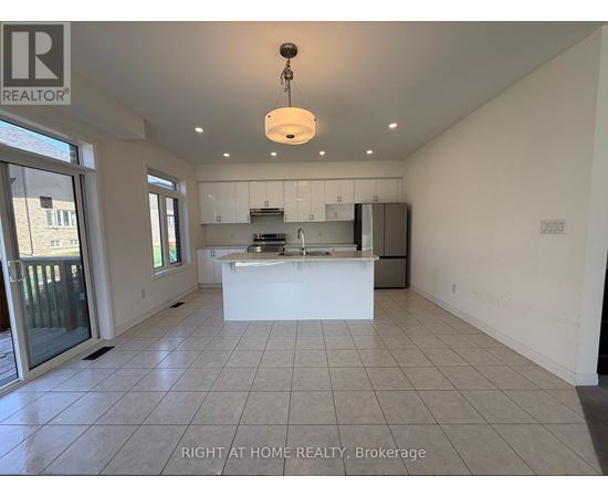 A spacious kitchen with white cabinets and a large island.