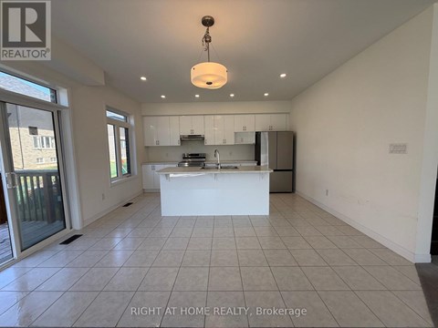 A spacious kitchen with white cabinets and a large island.