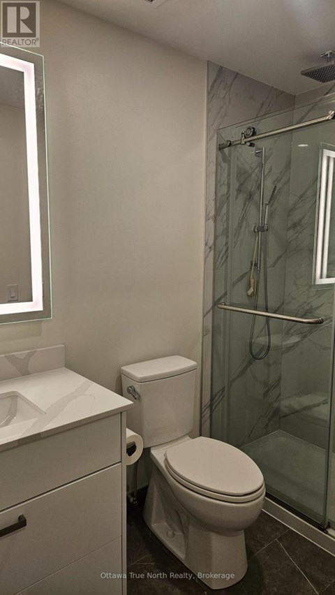 A white toilet in a bathroom with a glass shower door.