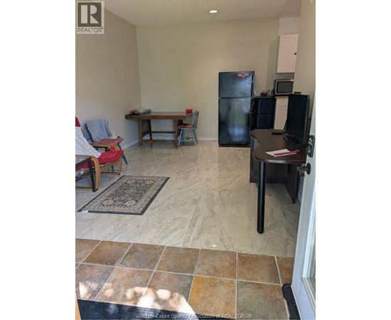 A kitchen area with a table, chairs, and a refrigerator.