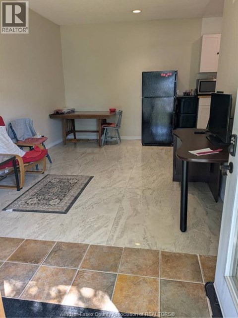 A kitchen area with a table, chairs, and a refrigerator.