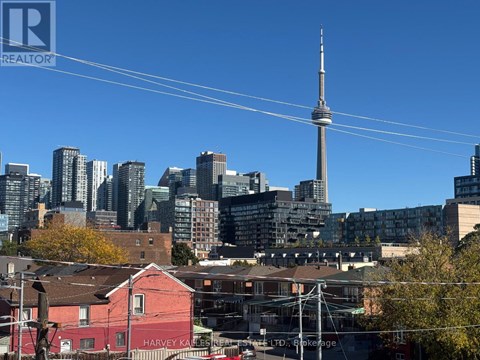 A cityscape with a tall tower in the background and a red building in the foreground.