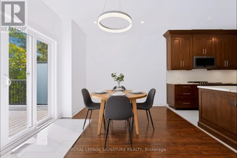 A dining room with a table set for two and a kitchen area in the background.