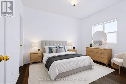A bedroom with a bed, nightstands, and a chair.