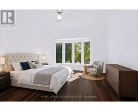 A bedroom with a large bed, a chair, and a ceiling fan.