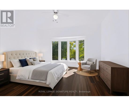 A bedroom with a large bed, a chair, and a ceiling fan.