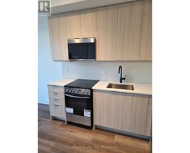 A kitchen with a stove and microwave above it.