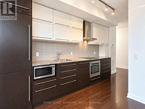 A kitchen with dark brown cabinets and white walls.