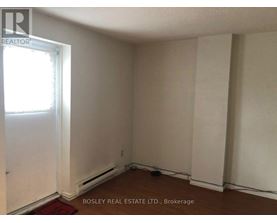 A room with a window and a door, with a sign that says "Bosley Real Estate Ltd., Brokerage".