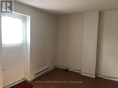 A room with a window and a door, with a sign that says "Bosley Real Estate Ltd., Brokerage".
