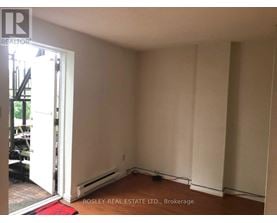A room with a doorway leading to a balcony and a red rug on the floor.