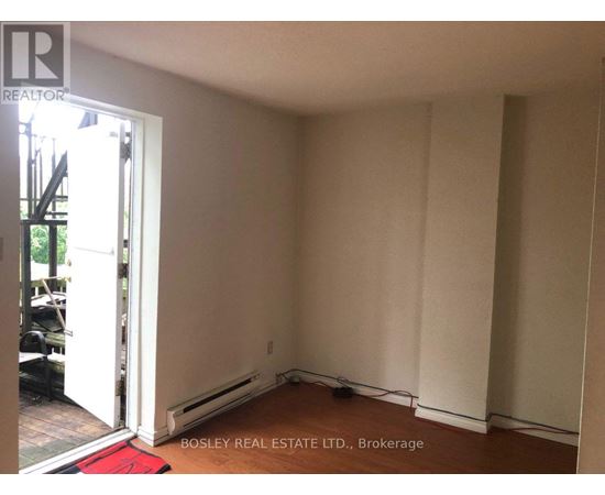 A room with a doorway leading to a balcony and a red rug on the floor.