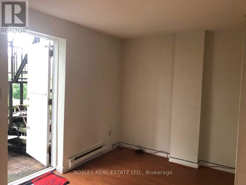 A room with a doorway leading to a balcony and a red rug on the floor.
