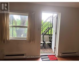 A room with a window and a door leading to a balcony.