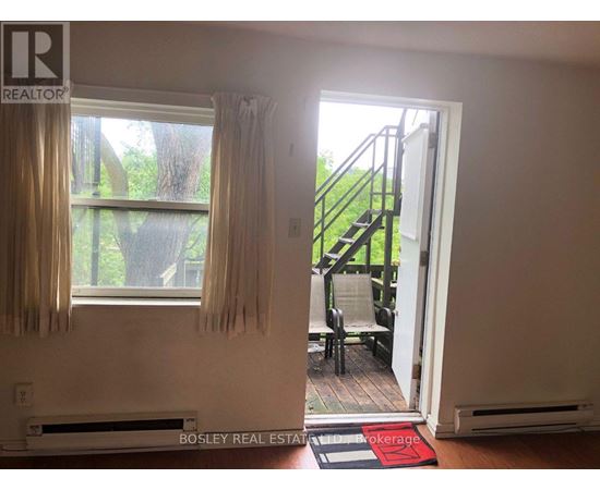 A room with a window and a door leading to a balcony.