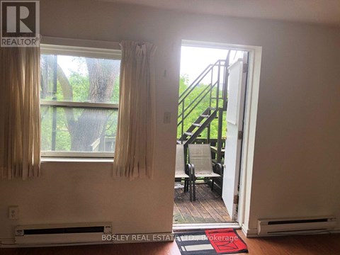 A room with a window and a door leading to a balcony.