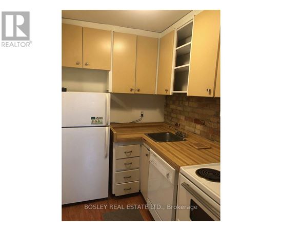 A kitchen with wooden cabinets and a white fridge.