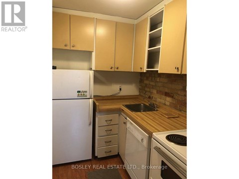 A kitchen with wooden cabinets and a white fridge.