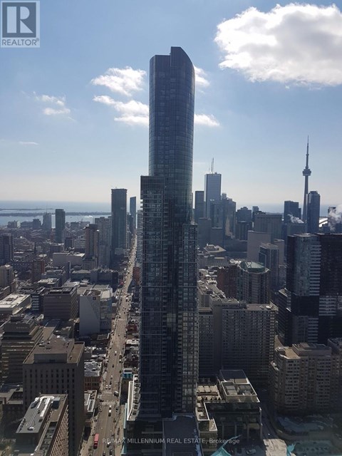 A cityscape with a tall building in the foreground and a bridge in the background.