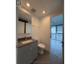 A bathroom with a toilet, sink, and mirror.