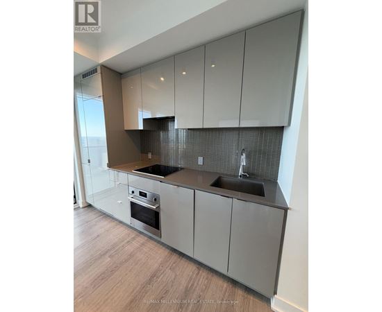 A modern kitchen with a stainless steel oven and sink.