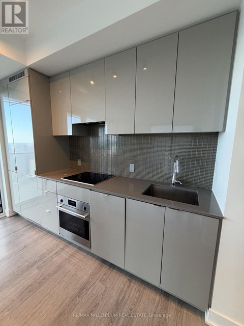 A modern kitchen with a stainless steel oven and sink.