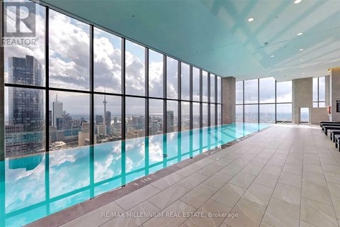 A large room with a pool and a view of the city.