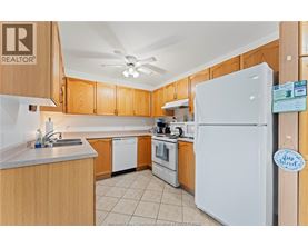 A kitchen with wooden cabinets and a white refrigerator.