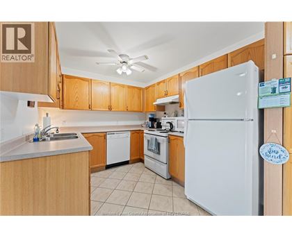A kitchen with wooden cabinets and a white refrigerator.