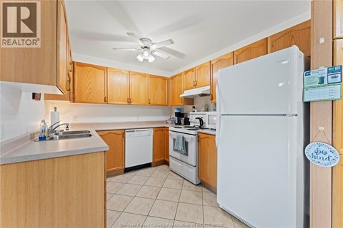 A kitchen with wooden cabinets and a white refrigerator.