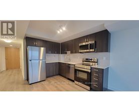 A modern kitchen with dark wood cabinets and stainless steel appliances.