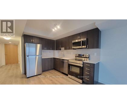 A modern kitchen with dark wood cabinets and stainless steel appliances.