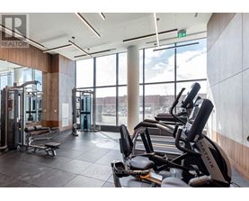 A gym with a row of treadmilers and a row of exercise bikes.