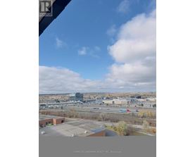 A view from a window of a cityscape with buildings and a highway.