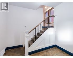 A wooden staircase with a metal railing and white balusters.