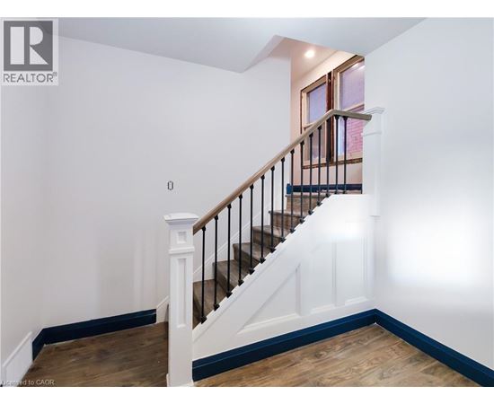 A wooden staircase with a metal railing and white balusters.