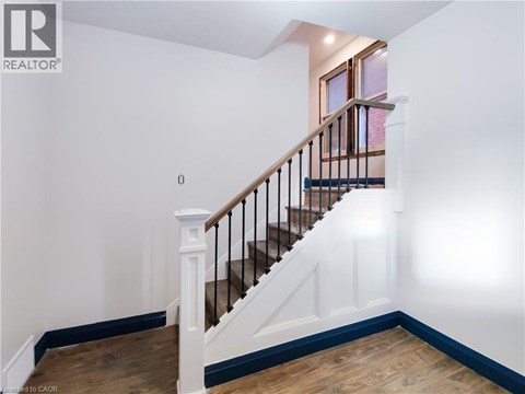 A wooden staircase with a metal railing and white balusters.