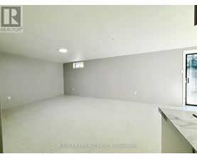 A large empty room with a window and a marble countertop.