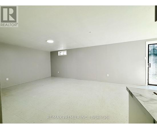 A large empty room with a window and a marble countertop.