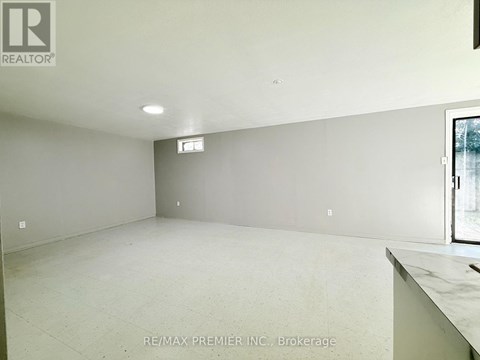 A large empty room with a window and a marble countertop.