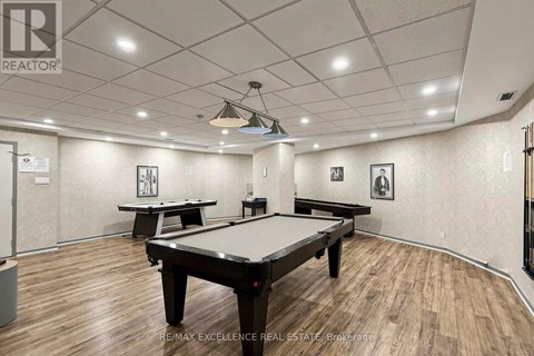 A room with a pool table and a billiard table.