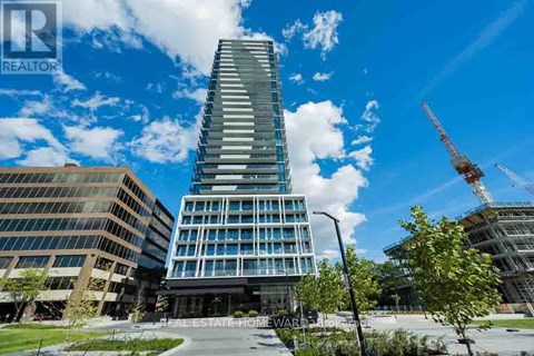 A tall building with a glass facade stands in front of a construction site.